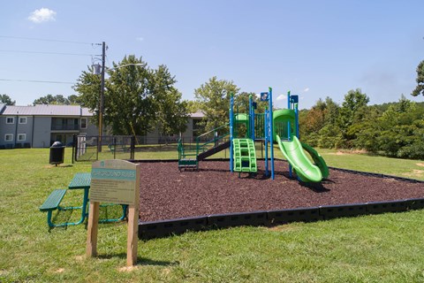 a playground with a slide and picnic table in a park