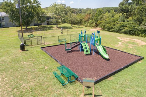 an aerial view of a playground with slides and chairs in a yard