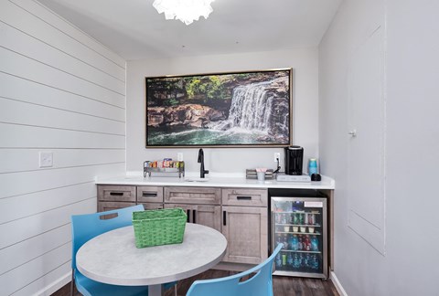 a dining room with a table and chairs and a picture of a waterfall