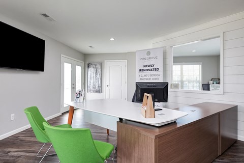 a home office with a desk and green chairs