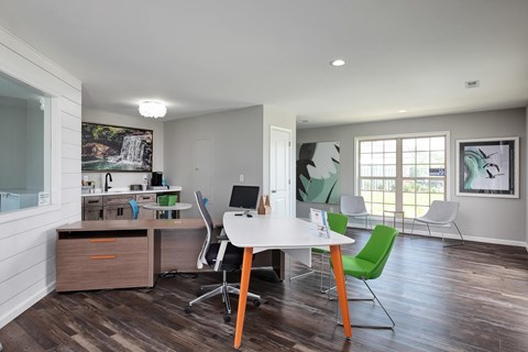a home office with a white table and green chairs