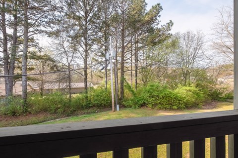 the view from the deck of a house overlooking a yard and trees