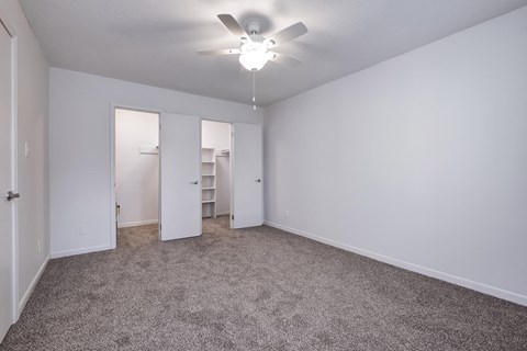 a bedroom with carpet and a ceiling fan