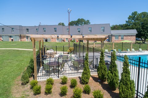 a patio with a table and chairs next to a pool
