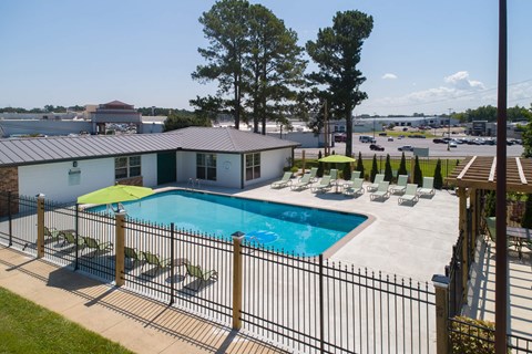 a swimming pool is shown at a hotel with lounge chairs