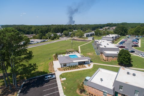 an aerial view of a neighborhood of houses with smoke in the background