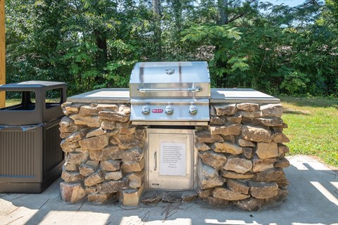 a gas grill in the middle of a stone wall