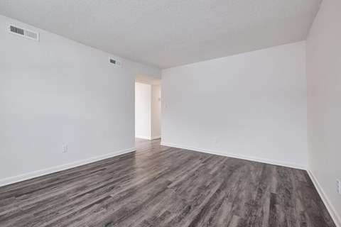 an empty living room with white walls and wood floors