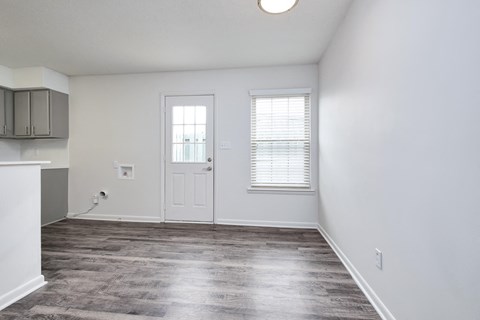 an empty living room with white walls and a white door