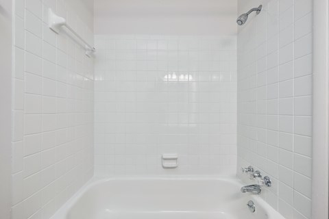 a white bathroom with a shower and a tub
