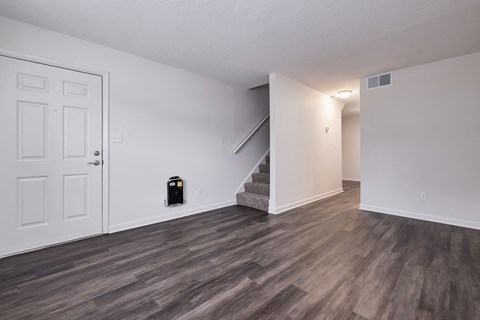 a living room with a staircase and a white door