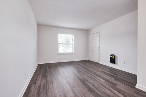 an empty living room with white walls and wood flooring