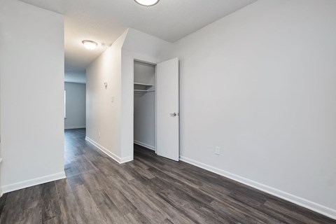 an empty living room with white walls and wood flooring