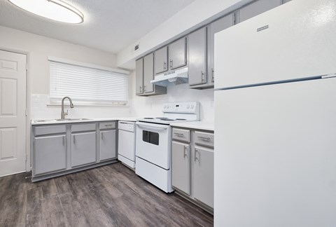 a white kitchen with white appliances and white cabinets