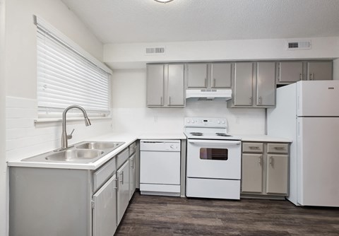 an empty kitchen with white appliances and stainless steel cabinets