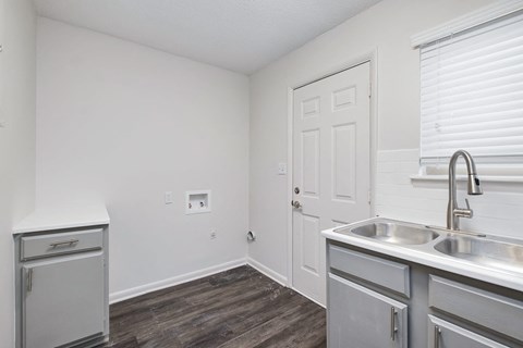 an empty kitchen with stainless steel appliances and a white door