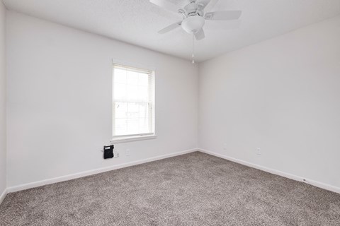 a room with carpet and a ceiling fan