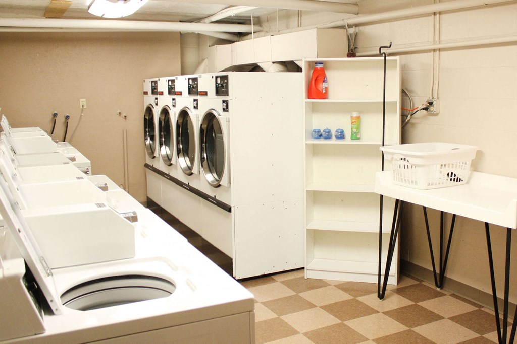 a laundry room with white appliances and a checkered floor