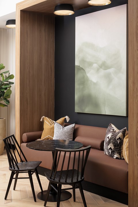 A modern dining area with a round table and two chairs.