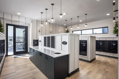 A modern kitchen with black and white cabinets and wooden floors.