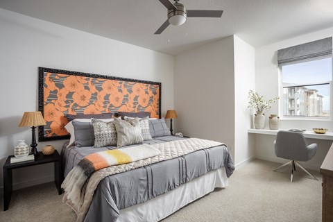 A bedroom with a large bed and a painting on the wall.