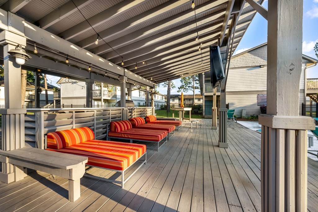 Poolside covered patio poolside covered patio with lounge chairs and TV at Retreat at Brightside Apartments in Baton Rouge, LA