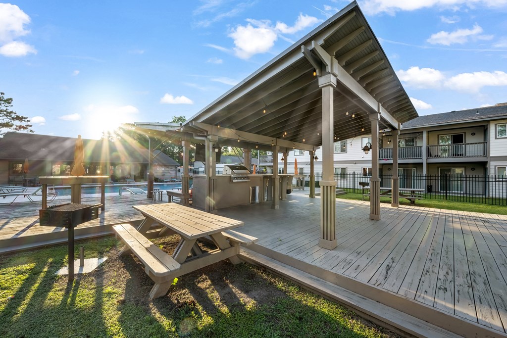 Deck with Picnic Table a deck with a picnic table and grill near swimming pool at Retreat at Brightside Apartments in Baton Rouge, LA