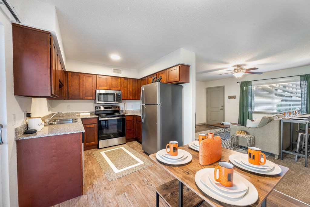 Kitchen and dining area a kitchen and dining area with wooden cabinets and stainless steel appliances at Retreat at Brightside Apartments in Baton Rouge, LA