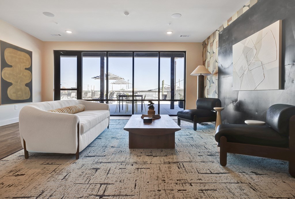 a living room with a white couch and a table and a balcony at Artisan Flats in Birmingham, AL