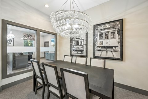 A dining room with a table and chairs and a chandelier.