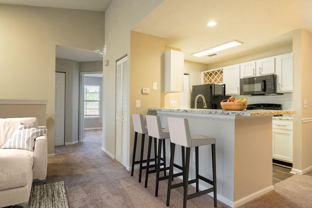 a kitchen with a bar and a living room with a couch