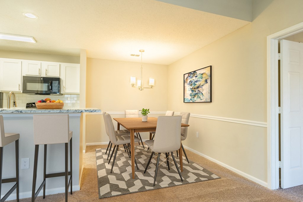 a dining room and kitchen with a table and chairs