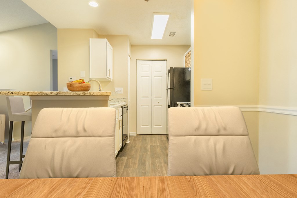 a living room with two chairs and a kitchen