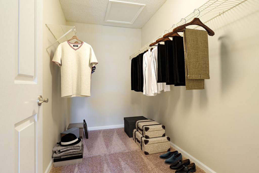 a walk in closet with clothes hanging on the wall and shoes on the floor