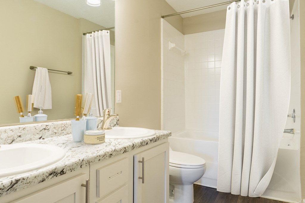 a bathroom with two sinks and a toilet and a shower