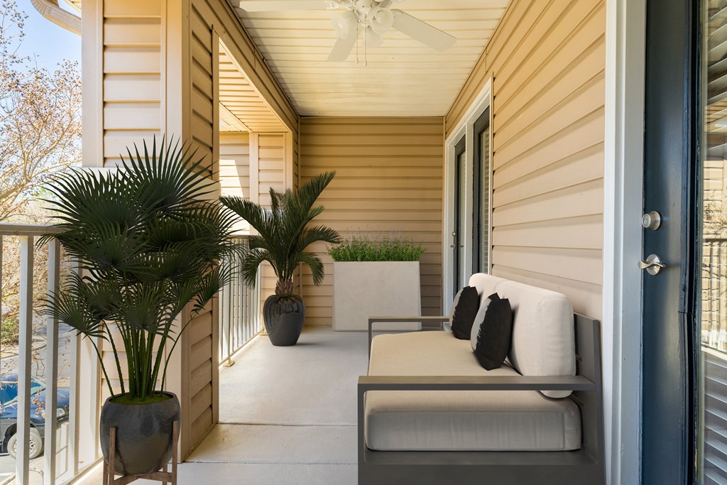 a covered porch with a couch and palm trees