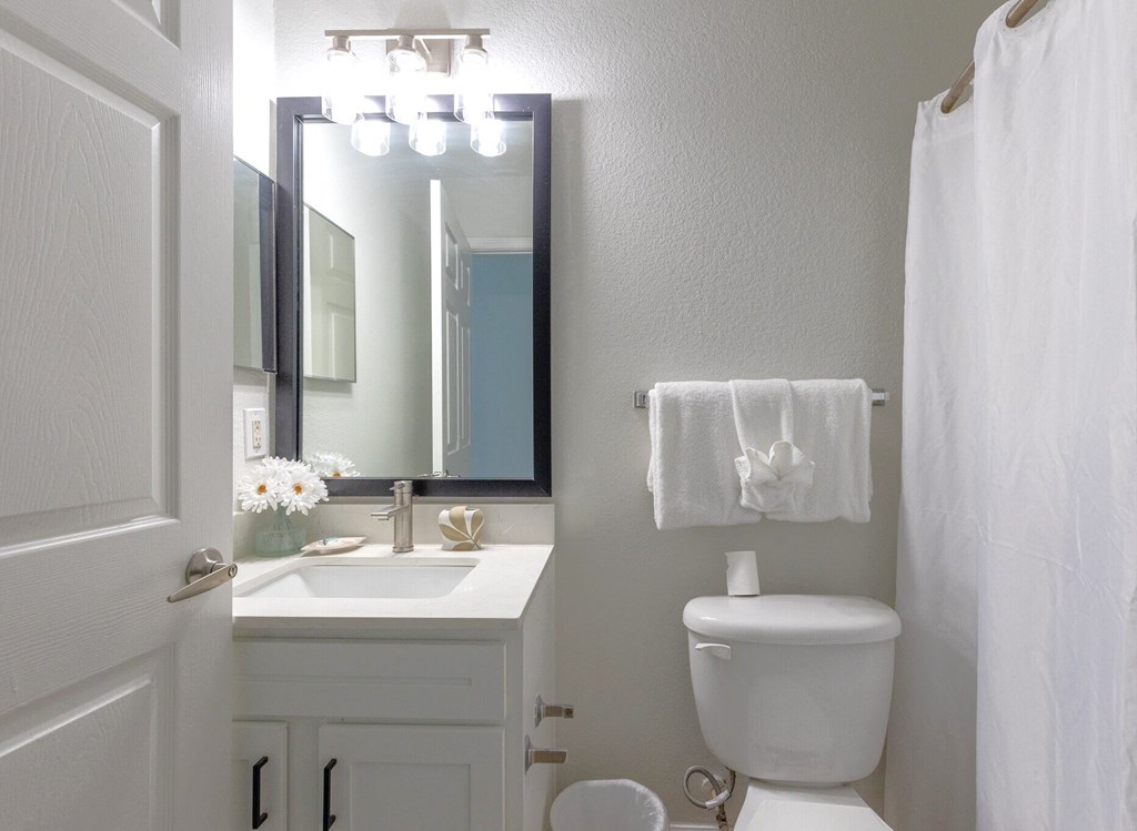 a white bathroom with a toilet and a sink