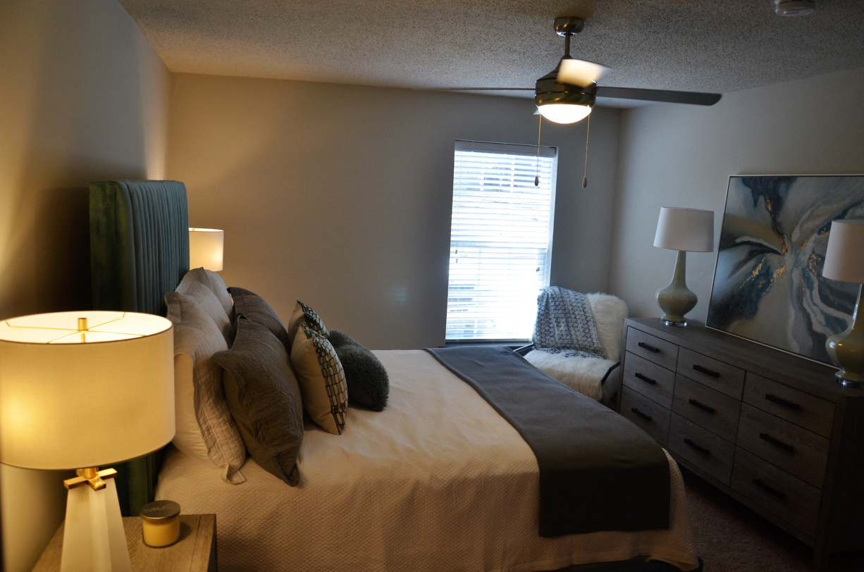 a bedroom with a bed and a dresser and a window