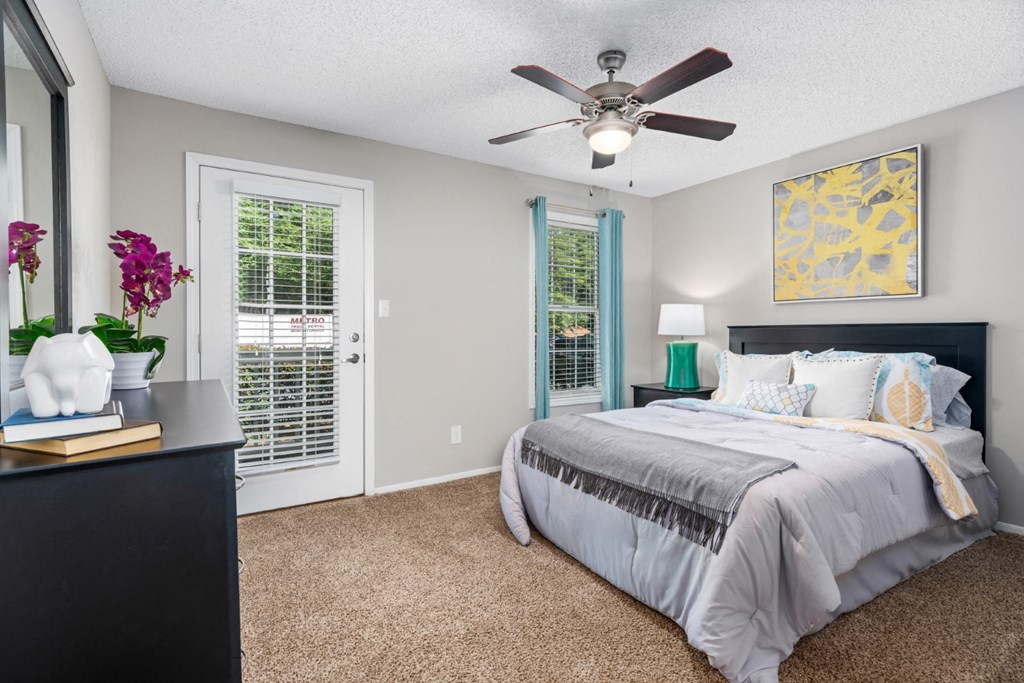 Carpeted bedroom with ceiling fan, door to patio at Summerchase at Riverchase in Hoover, Alabama