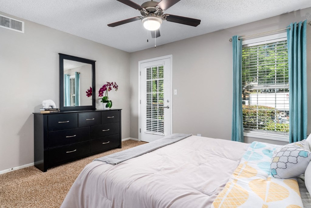 Carpeted bedroom with ceiling fan, door to patio at Summerchase at Riverchase in Hoover, Alabama