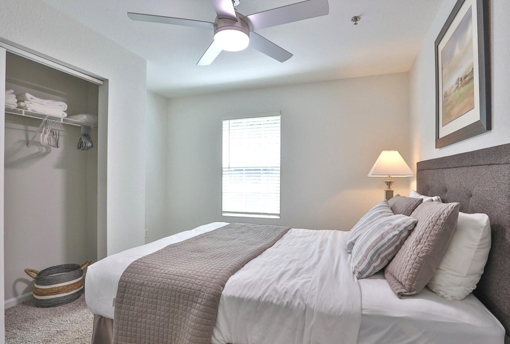 a bedroom with a large bed and a ceiling fan