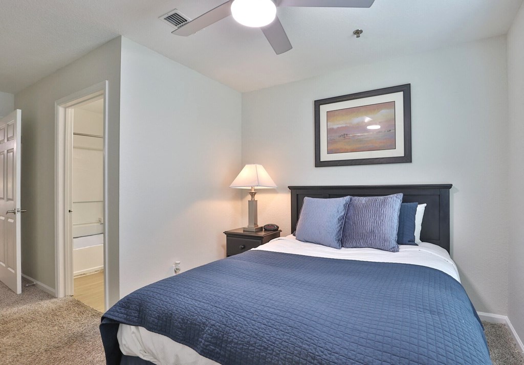 a bedroom with a bed and a ceiling fan