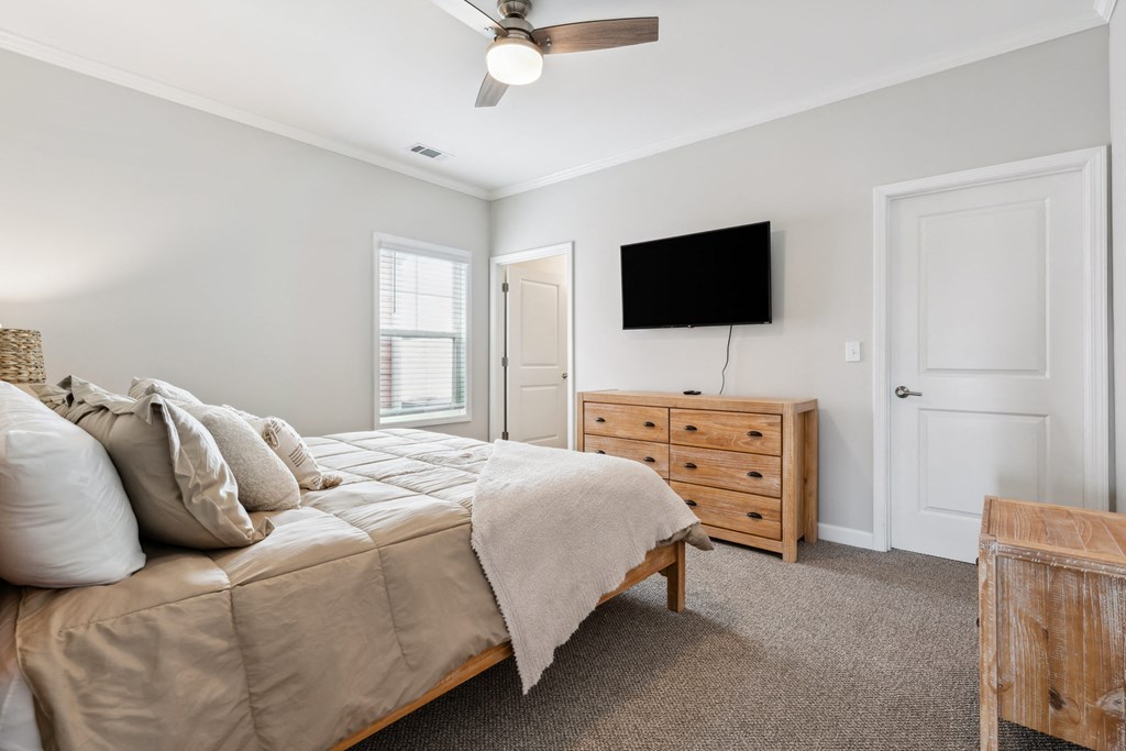 a bedroom with a bed and a dresser with a tv