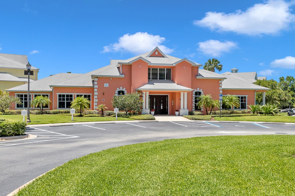 a large orange building with a lawn in front of it