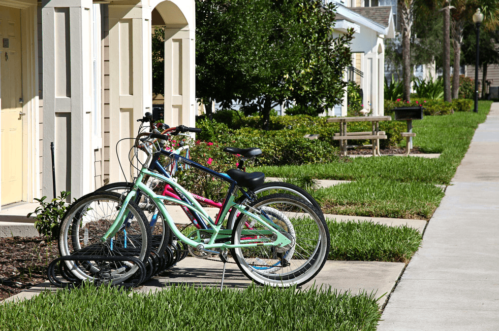 two bikes parked on the sidewalk in front of a house