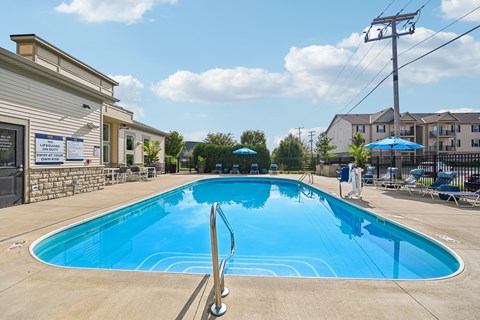 A large outdoor swimming pool with a diving board.