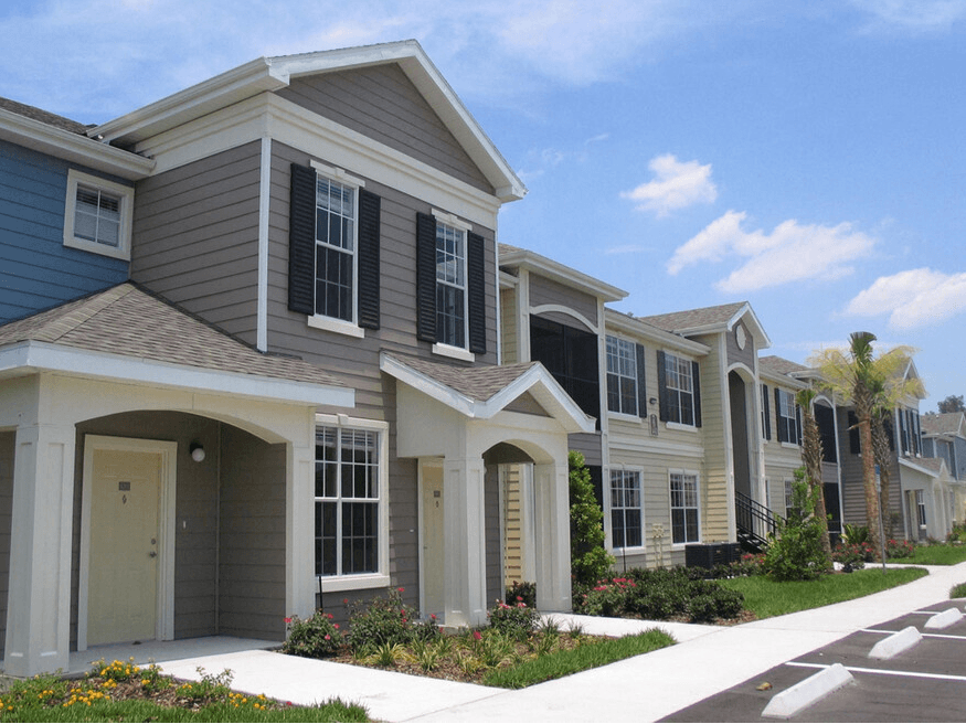 a row of townhomes with a sidewalk in front of them