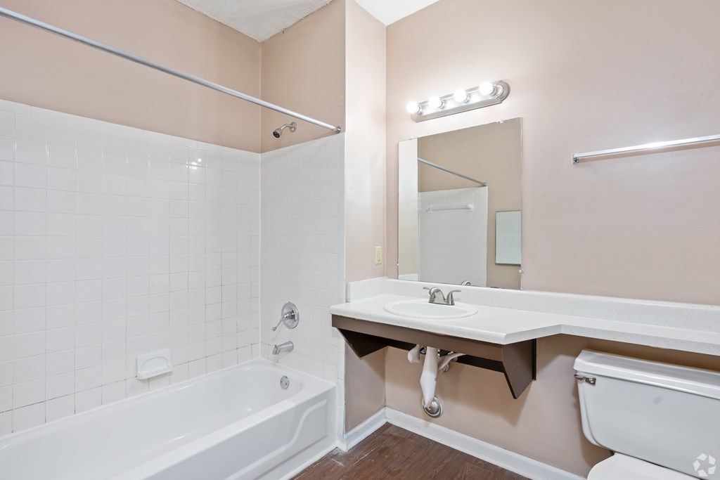A bathroom with a white tub and sink.