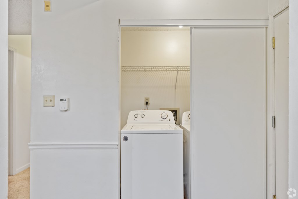 A white laundry room with a washer and dryer.