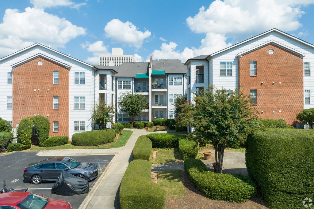 A large apartment complex with a parking lot in front.